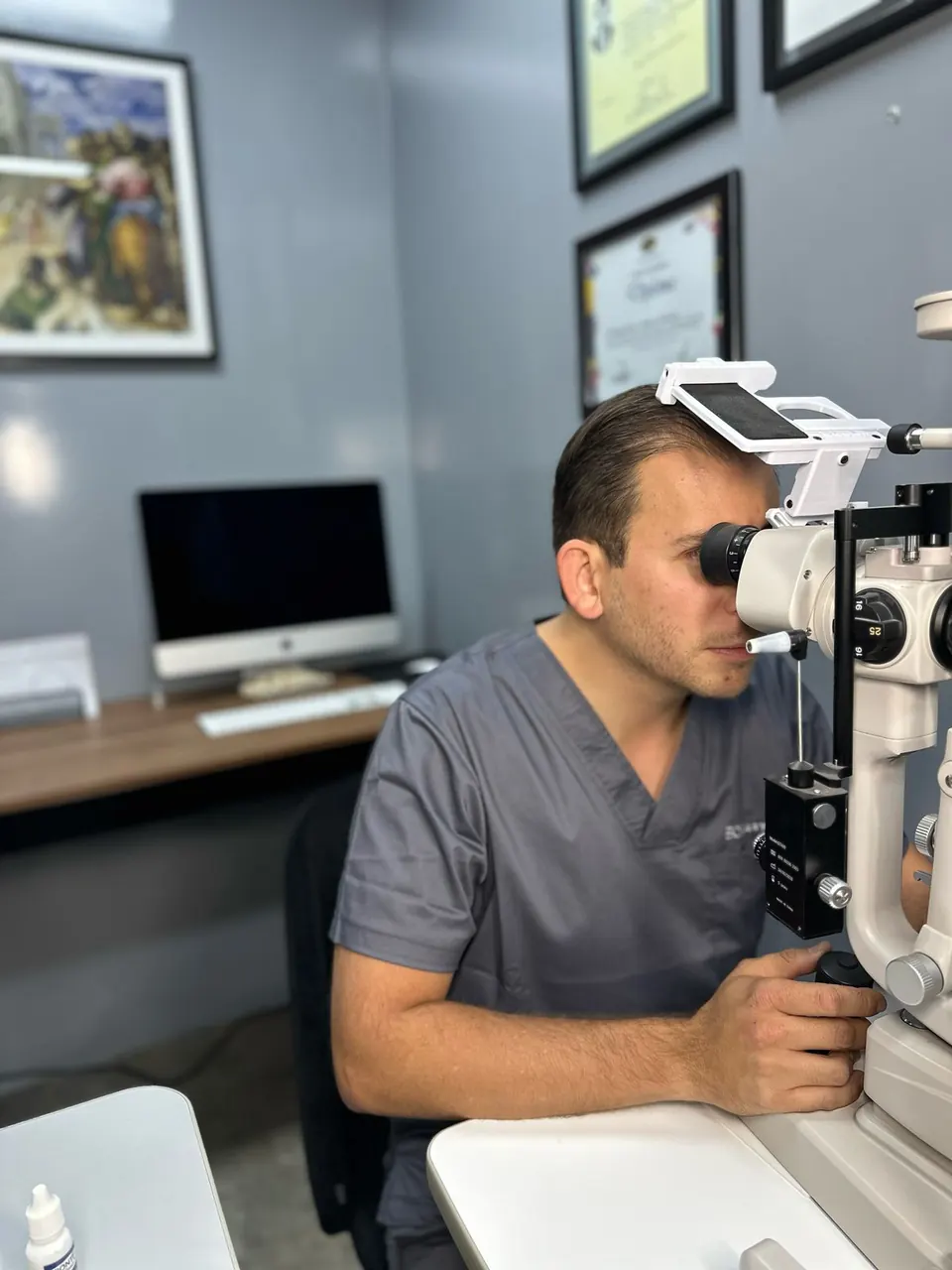 El Dr. Morfín explorando con la lámpara de hendidura en su consultorio